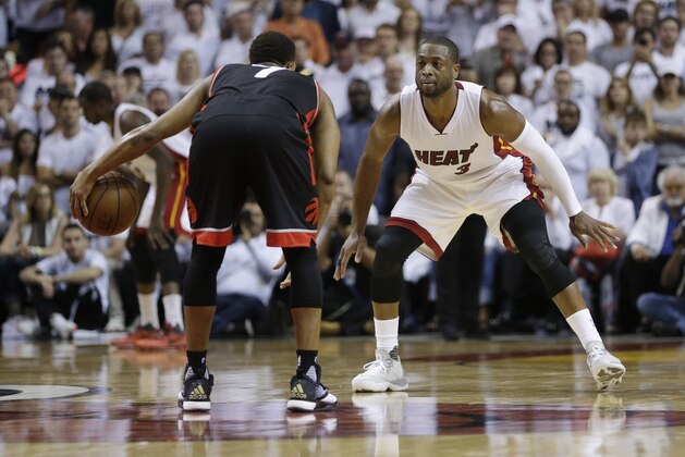 Miami Heat guard Dwyane Wade (3) defends Toronto Raptors guard Kyle Lowry (7), during the second half of Game 3 of an NBA second-round playoff basketball series Saturday, May 7, 2016, in Miami. (AP Photo/Alan Diaz)