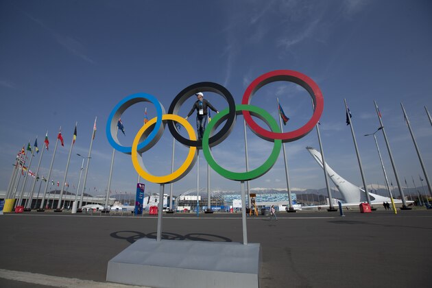 A visitor poses on the Olympic rings after the 2014 Winter Olympics, Monday, Feb. 24, 2014, in Sochi, Russia. (AP Photo/Matt Slocum)