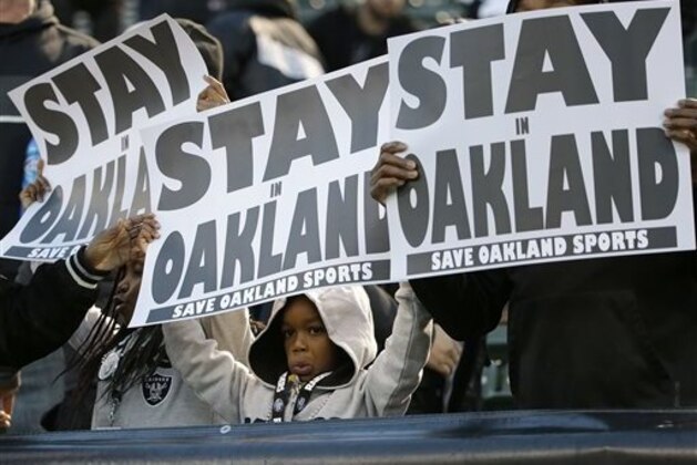 FILE - In this Dec. 24, 2015 file photo, fans hold up a sign for the Oakland Raiders to stay in Oakland before an NFL football game between the Oakland Raiders and the San Diego Chargers in Oakland, Calif. oakland Raiders owner Mark Davis says he wants to move the team to Las Vegas and is willing to spend a half billion dollars as part of a deal for a new stadium in the city. Davis upped the ante in a bid to move the team to this gambling city, appearing Thursday, April 28, 2016, alongside soccer great David Beckham and billionaire casino owner Sheldon Adelson before a committee studying the idea of a $1.4 billion stadium. (AP Photo/Marcio Jose Sanchez)