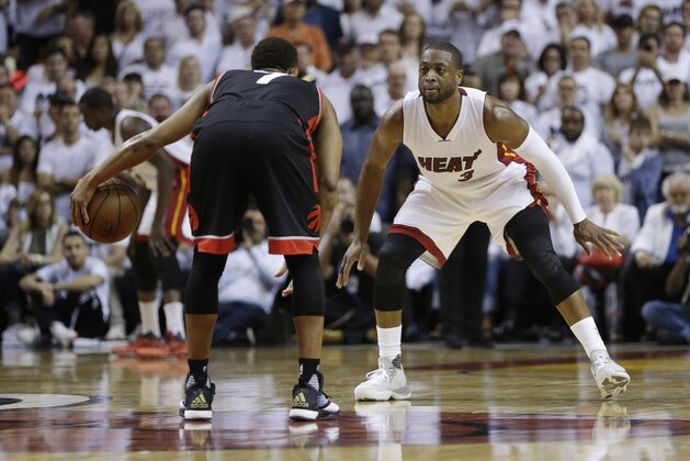 Miami Heat guard Dwyane Wade (3) defends Toronto Raptors guard Kyle Lowry (7), during the second half of Game 3 of an NBA second-round playoff basketball series Saturday, May 7, 2016, in Miami. (AP Photo/Alan Diaz)
