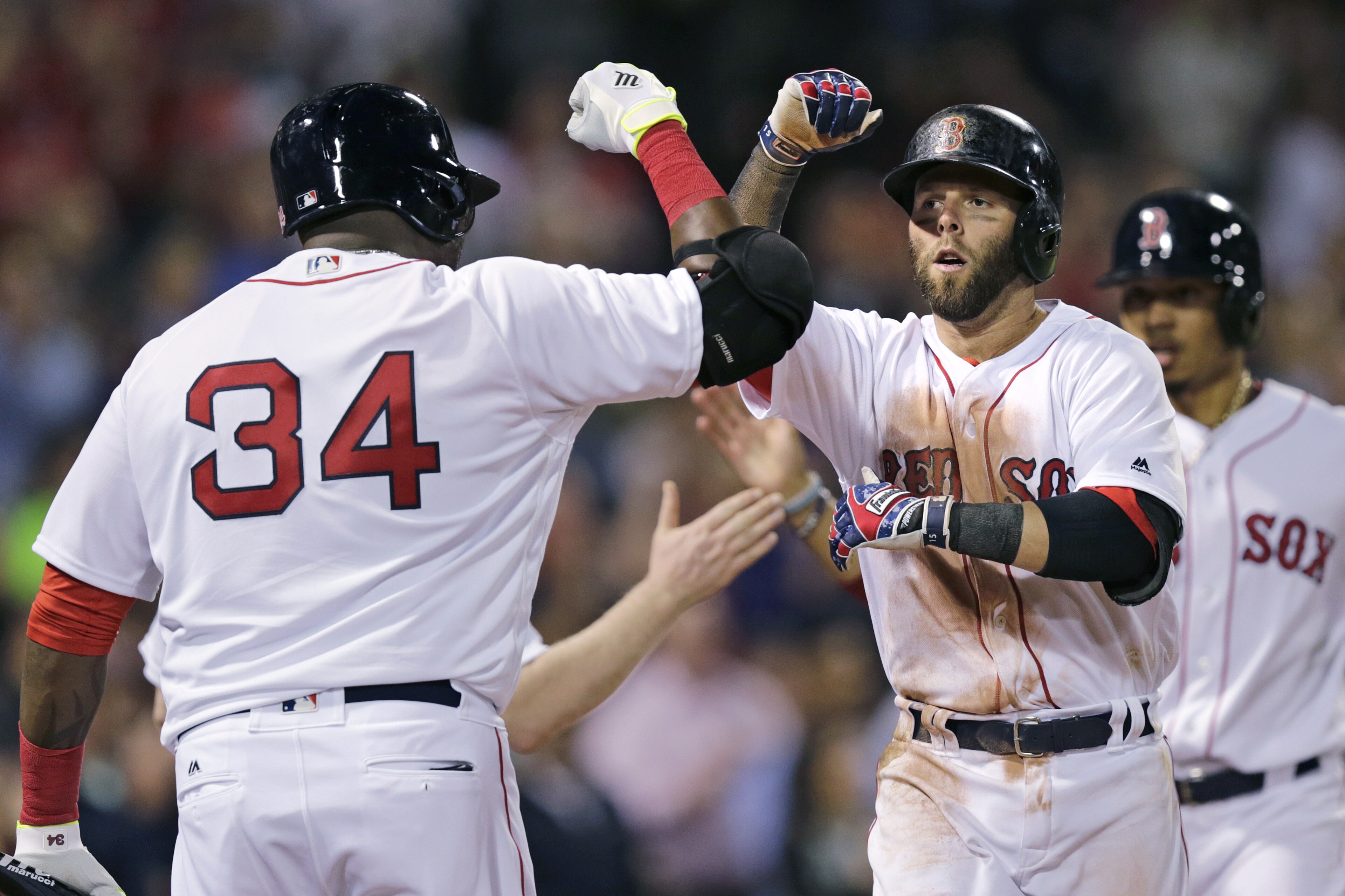 Boston Red Sox's Dustin Pedroia, right, is congratulated by David Ortiz (34) after his two run home run off Oakland Athletics relief pitcher Ryan Dull during the fourth inning of a baseball game at Fenway Park in Boston, Wednesday, May 11, 2016. (AP Photo/Charles Krupa)