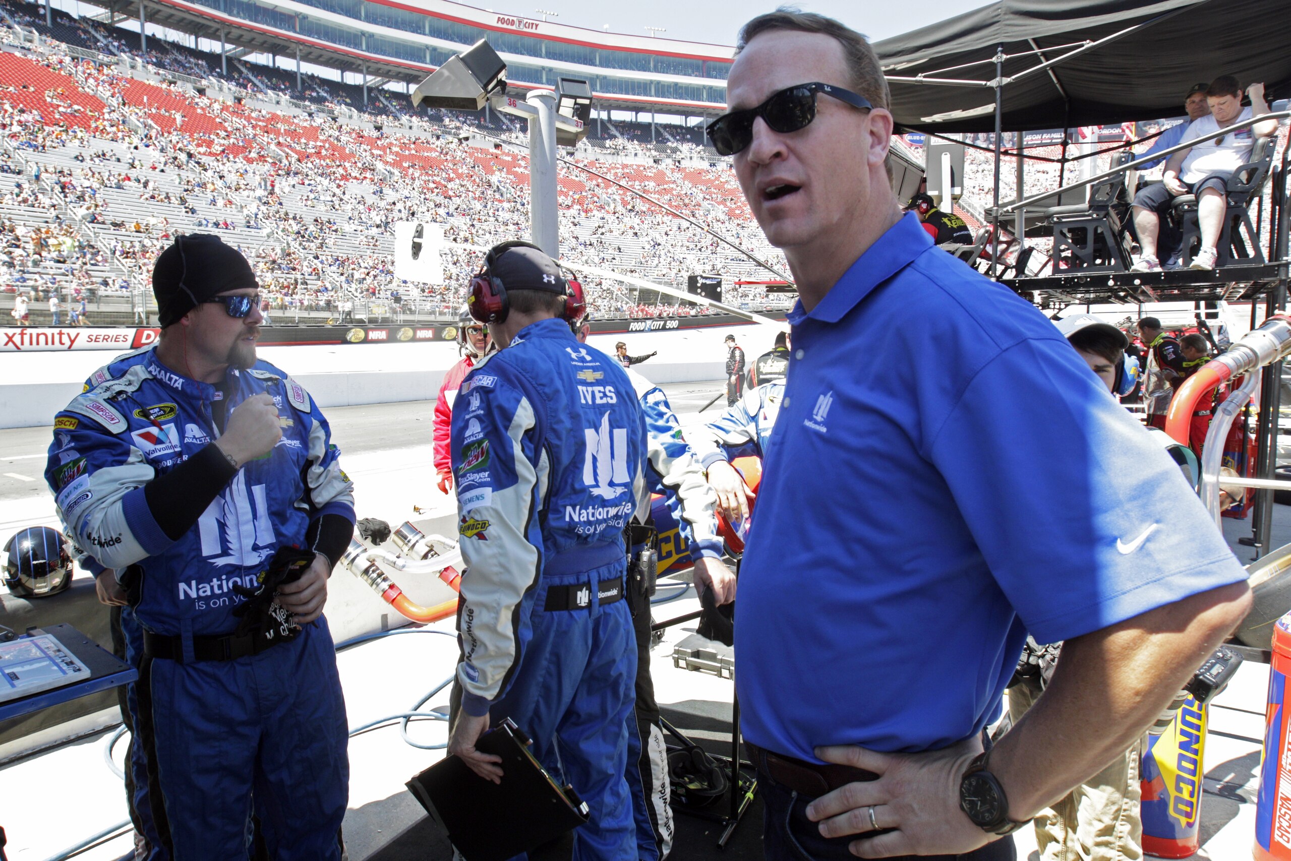 Former University Tennessee and Denver Broncs quarterback Peyton Manning watches from the pit box of Sprint Cup Series driver Dale Earnhardt Jr. (88) before a NASCAR Sprint Cup Series auto race, Sunday, April 17, 2016 in Bristol, Tenn. (AP Photo/Wade Payne)