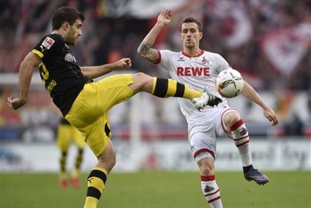 Dortmund's Sokratis, left, and Cologne's Simon Zoller challenge for the ball during the German Bundesliga soccer match between 1.FC Cologne and Borussia Dortmund in Cologne, Germany, Saturday, Dec. 19, 2015. (AP Photo/Martin Meissner)