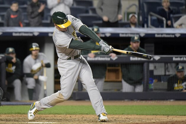 Oakland Athletics' Mark Canha hits an RBI-single during the 11th inning of a baseball game against the New York Yankees Tuesday, April 19, 2016, at Yankee Stadium in New York. The Athletics defeated the Yankees 3-2. (AP Photo/Bill Kostroun)