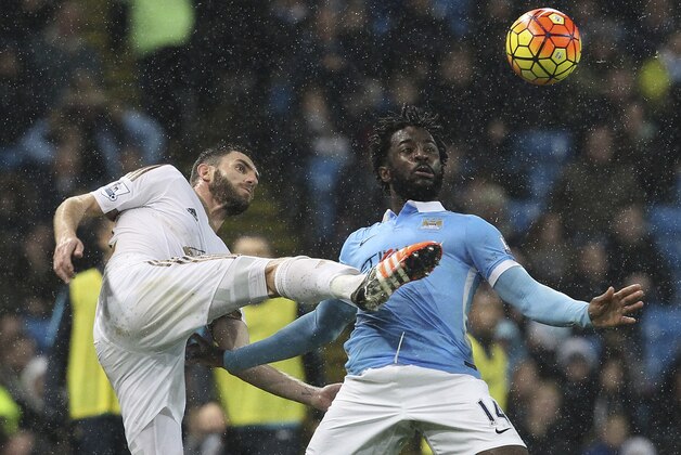 Swansea City's Spanish defender Angel Rangel (L) vies with Manchester City's Ivorian striker Wilfried Bony (R) during the English Premier League football match between Manchester City and Swansea City at the Etihad Stadium in Manchester, north west England, on December 12, 2015. AFP PHOTO / LINDSEY PARNABY

RESTRICTED TO EDITORIAL USE. No use with unauthorized audio, video, data, fixture lists, club/league logos or 'live' services. Online in-match use limited to 75 images, no video emulation. No use in betting, games or single club/league/player publications. / AFP / LINDSEY PARNABY        (Photo credit should read LINDSEY PARNABY/AFP/Getty Images)