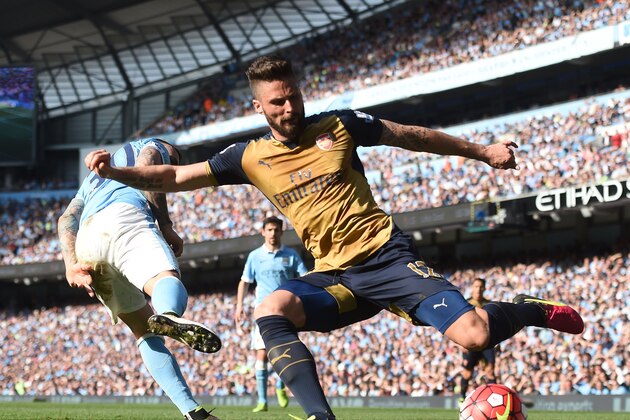 Arsenal's French striker Olivier Giroud (R) crosses the ball by Manchester City's Argentinian defender Nicolas Otamendi during the English Premier League football match between Manchester City and Arsenal at the Etihad Stadium in Manchester, north west England, on May 8, 2016. / AFP / PAUL ELLIS / RESTRICTED TO EDITORIAL USE. No use with unauthorized audio, video, data, fixture lists, club/league logos or 'live' services. Online in-match use limited to 75 images, no video emulation. No use in betting, games or single club/league/player publications.  /         (Photo credit should read PAUL ELLIS/AFP/Getty Images)