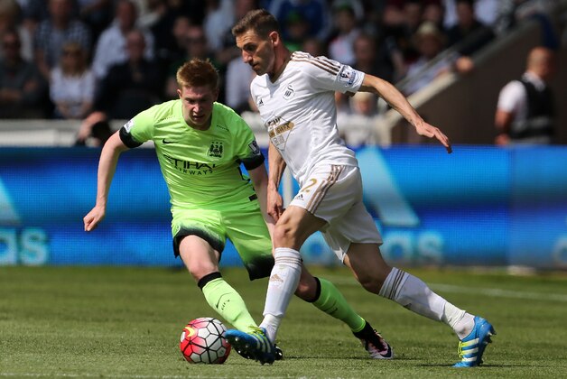Manchester City's Belgian midfielder Kevin De Bruyne (L) vies with Swansea City's Spanish defender Angel Rangel the English Premier League football match between Swansea City and Manchester City at The Liberty Stadium in Swansea, south Wales on May 15, 2016. / AFP / GEOFF CADDICK / RESTRICTED TO EDITORIAL USE. No use with unauthorized audio, video, data, fixture lists, club/league logos or 'live' services. Online in-match use limited to 75 images, no video emulation. No use in betting, games or single club/league/player publications.  /         (Photo credit should read GEOFF CADDICK/AFP/Getty Images)