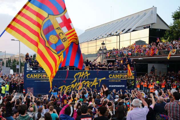 Supporters wave FC Barcelona flags as their team parades on a bus through the streets of Barcelona to celebrate their 24th La Liga title, in Barcelona, on May 15, 2016
Barcelona sealed their 24th La Liga title on May 14, 2016 at Granada to hold off Real Madrid's late-season surge.

 / AFP / PAU BARRENA        (Photo credit should read PAU BARRENA/AFP/Getty Images)
