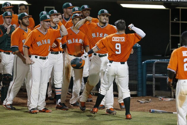 CORAL GABLES, FL - May 13: Teammates congratulate Carl Chester #9 of the Miami Hurricanes after he hit a three run home run against the Pittsburgh Panthers during eighth inning action on May 13, 2016 at Alex Rodriguez Park at Mark Light Field in Coral Gables, Florida. Miami defeated Pittsburgh 7-6. (Photo by Joel Auerbach/Getty Images)