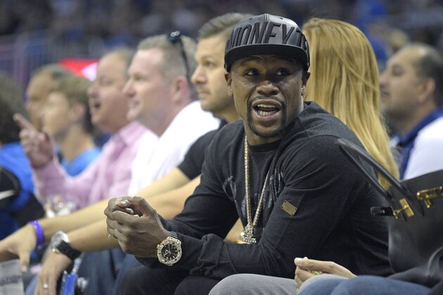 Boxer Floyd Mayweather Jr. talks to a fan while sitting court side during the first half of an NBA basketball game between the Orlando Magic and the Oklahoma City Thunder in Orlando, Fla., Friday, Oct. 30, 2015. The Thunder won 139-136 in double overtime. (AP Photo/Phelan M. Ebenhack)