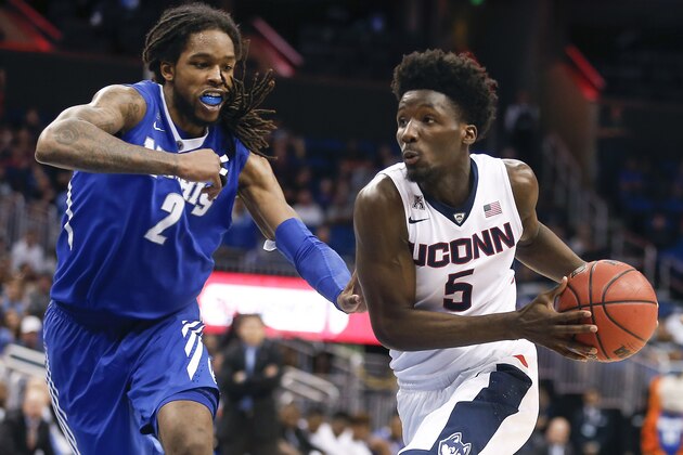 Mar 13, 2016; Orlando, FL, USA; Connecticut Huskies guard Daniel Hamilton (5) drives past Memphis Tigers forward Shaq Goodwin (2) during the second half of the AAC Conference tournament at Amway Center. Connecticut won 72-58. Mandatory Credit: Reinhold Matay-USA TODAY Sports