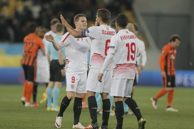 Goal scorer Sevilla’s Kevin Gameiro, left, high fives his captain Daniel Carrico next to Ever Banega, right, at the end of the semifinal first leg of the Europa League soccer match, between FC Shakhtar Donetsk and Sevilla at Arena Lviv stadium in Lviv, western Ukraine, Thursday, April  28, 2016. (AP Photo/Efrem Lukatsky)