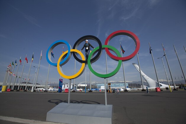 A visitor poses on the Olympic rings after the 2014 Winter Olympics, Monday, Feb. 24, 2014, in Sochi, Russia. (AP Photo/Matt Slocum)