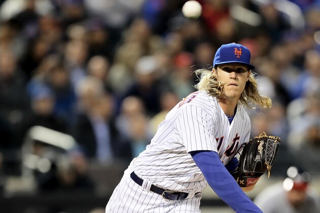 NEW YORK, NY - MAY 17:  Noah Syndergaard #34 of the New York Mets tries to pick off Daniel Murphy of the Washington Nationals at first base in the fourth inning at Citi Field on May 17, 2016 in the Flushing neighborhood of the Queens borough of New York City.  (Photo by Elsa/Getty Images)