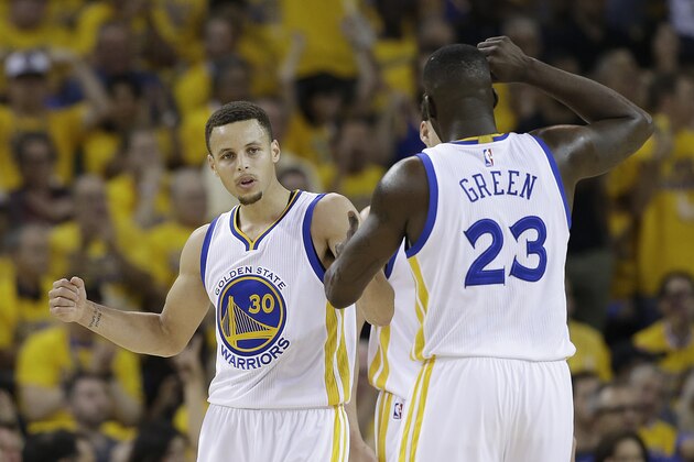 Golden State Warriors guard Stephen Curry (30) and forward Draymond Green (23) react after scoring against the Oklahoma City Thunder during the first half of Game 2 of the NBA basketball Western Conference finals in Oakland, Calif., Wednesday, May 18, 2016. (AP Photo/Marcio Jose Sanchez)