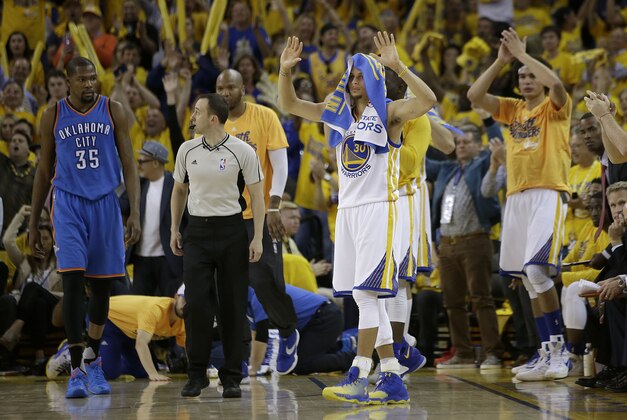 Oklahoma City Thunder forward Kevin Durant (35) watches as Golden State Warriors guard Stephen Curry (30) and fans celebrate during the second half of Game 2 of the NBA basketball Western Conference finals in Oakland, Calif., Wednesday, May 18, 2016. The Warriors won 118-91. (AP Photo/Marcio Jose Sanchez)