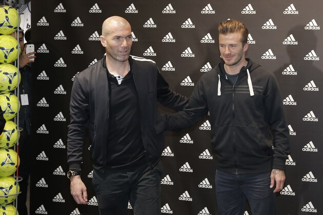 Retired soccer player Zinedine Zidane, left, and Paris Saint-Germain's David Beckham pose for a photograph, during a media event at a sports store on the Champs Elysees, in Paris, Thursday, Feb. 28, 2013. (AP Photo/Francois Mori)