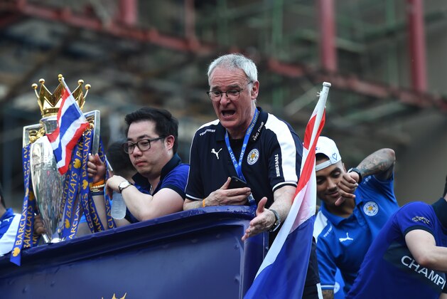 Leicester City's Italian manager Claudio Ranieri (C) gestures as he along with the club's football players and owners parade in an open-bus with the Premier League trophy through Bangkok on May 19, 2016.
Newly crowned English Premier League champions Leicester City received a royal seal of approval on May 19 at Bangkok's Grand Palace, with the Thai-owned team presenting its trophy to a portrait of the king before a bus parade through the capital. / AFP / CHRISTOPHE ARCHAMBAULT        (Photo credit should read CHRISTOPHE ARCHAMBAULT/AFP/Getty Images)