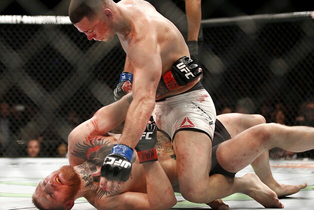 Nate Diaz, top, trades punches Conor McGregor during their UFC 196 welterweight mixed martial arts match, Saturday, March 5, 2016, in Las Vegas.  Diaz won by submission in the second round. (AP Photo/Eric Jamison)