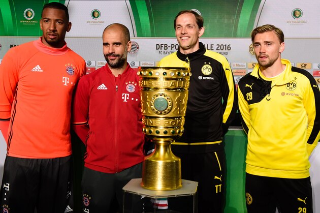 (From L) Bayern Munich's defender Jerome Boateng, Bayern Munich's Spanish head coach Pep Guardiola, Dortmund's head coach Thomas Tuchel and Dortmund's defender Marcel Schmelzer pose behind the German Cup (DFB Pokal) trophy on the eve of the German Cup final football match Bayern Munich vs Borussia Dortmund at the Olympic stadium in Berlin on May 20, 2016. / AFP / TOBIAS SCHWARZ        (Photo credit should read TOBIAS SCHWARZ/AFP/Getty Images)