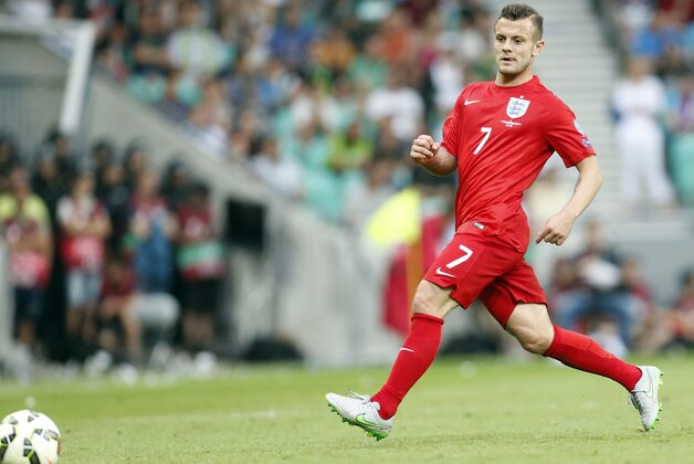 England's Jack Wilshere, right, passes the ball during the Euro 2016 Group E qualifying soccer match between Slovenia and England, in Ljubljana, Slovenia, Sunday, June 14, 2015. (AP Photo/Darko Bandic)