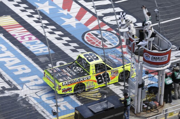 Matt Crafton (88) takes the checkered flag to win the NASCAR Truck Series North Carolina Education Lottery 200 auto race at the Charlotte Motor Speedway in Concord, N.C., Saturday, May 21, 2016. (AP Photo/Gerry Broome)