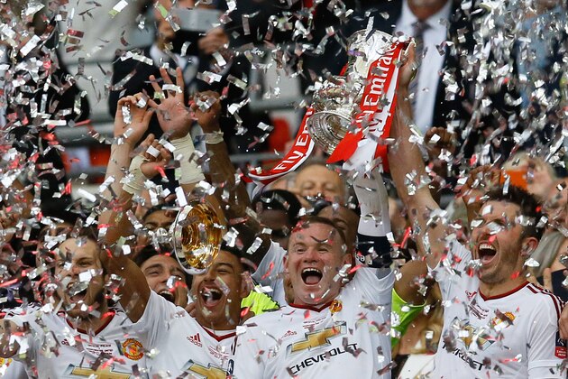 A piece of the trophy falls off as United’s Wayne Rooney lifts it celebrating after they won the English FA Cup final soccer match between Manchester United and Crystal Palace at Wembley stadium in London, Saturday, May 21, 2016. United won 2-1. (AP Photo/Kirsty Wigglesworth)