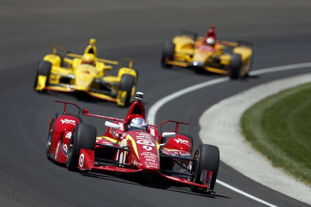 Scott Dixon, of New Zealand, drives through the first turn in front of Helio Castroneves, of Brazil, and Ryan Hunter-Reay during a practice session for the Indianapolis 500 auto race at Indianapolis Motor Speedway in Indianapolis, Thursday, May 19, 2016. (AP Photo/Michael Conroy)