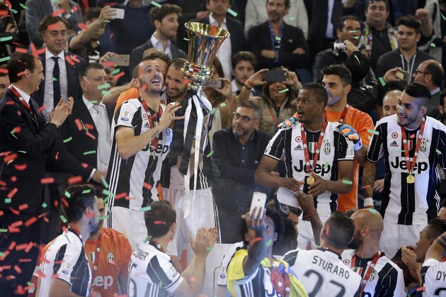 Juventus' players celebrate with the trophy at the end of the Italian Cup soccer final between AC Milan and Juventus, at Rome's Olympic Stadium, Saturday, May 21, 2016. Substitute Alvaro Morata scored in extra time and Juventus beat AC Milan 1-0 to win the Italian Cup on Saturday, becoming the first club to win the league and cup double in consecutive seasons. (AP Photo/Andrew Medichini) Juventus' players celebrate with the trophy at the end of the Italian Cup soccer final between AC Milan and Juventus, at Rome's Olympic Stadium, Saturday, May 21, 2016. Substitute Alvaro Morata scored in extra time and Juventus beat AC Milan 1-0 to win the Italian Cup on Saturday, becoming the first club to win the league and cup double in consecutive seasons. (AP Photo/Andrew Medichini)