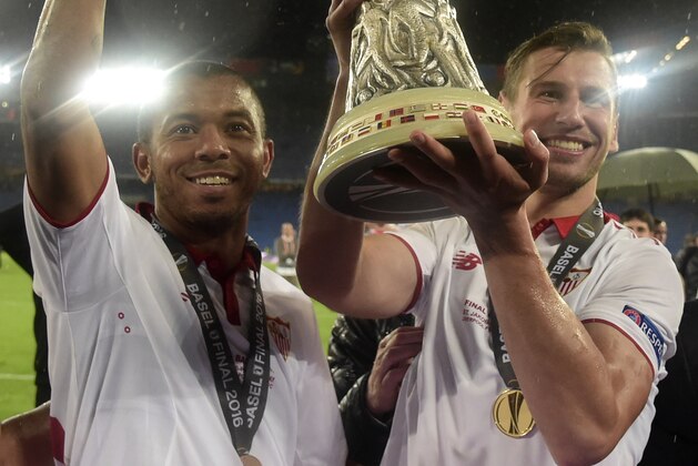 Sevilla's Brazilian defender Mariano Ferreira and Sevilla's Polish midfielder Grzegorz Krychowiak celebrate with the trophy after winning the UEFA Europa League final football match between Liverpool FC and Sevilla FC at the St Jakob-Park stadium in Basel, on May 18, 2016.  AFP PHOTO / JAVIER SORIANO / AFP / JAVIER SORIANO        (Photo credit should read JAVIER SORIANO/AFP/Getty Images)