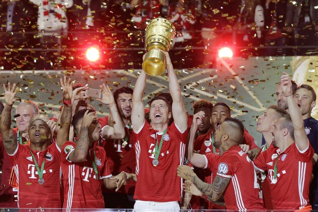 Bayern's Robert Lewandowski holds up the trophy after the German soccer cup final match between Borussia Dortmund and FC Bayern Munich in Berlin, Germany, Saturday, May 21, 2016. (AP Photo/Markus Schreiber)