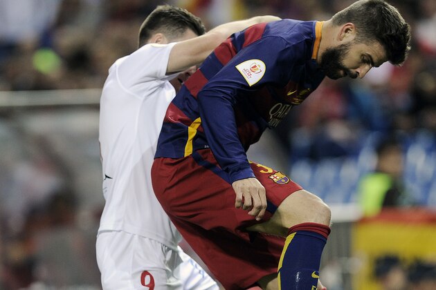 Sevilla's French forward Kevin Gameiro (L) vies with Barcelona's defender Gerard Pique during the Spanish 'Copa del Rey' (King's Cup) final match FC Barcelona vs Sevilla FC at the Vicente Calderon stadium in Madrid on May 22, 2016. / AFP / CRISTINA QUICLER        (Photo credit should read CRISTINA QUICLER/AFP/Getty Images)
