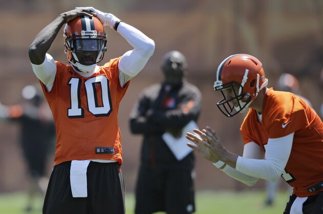 Cleveland Browns quarterback Robert Griffin III, left, takes a break as he watches quarterback Austin Davis take a snap during practice at the NFL football team's training camp facility, Wednesday, May 18, 2016, in Berea, Ohio. (AP Photo/Tony Dejak)