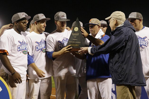 SEC commissioner Mike Slive presents the championship trophy to Florida players after they beat Vanderbilt in the Southeastern Conference NCAA college baseball tournament championship game at the Hoover Met, Sunday, May 24, 2015, in Hoover, Ala. Florida won 7-3. (AP Photo/Butch Dill)