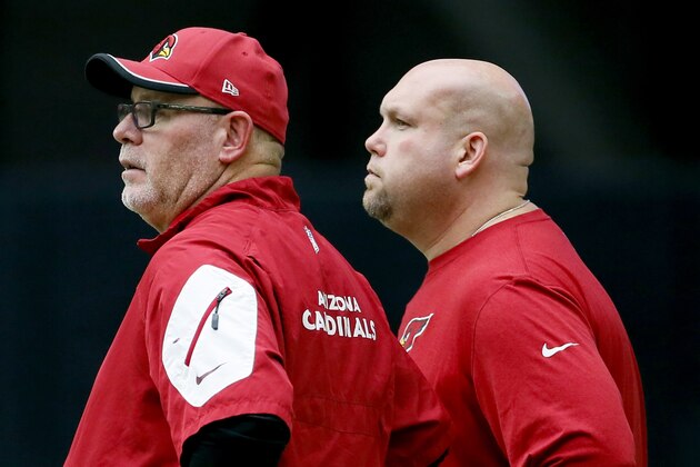 Arizona Cardinals head coach Bruce Arians, front, and G.M. Steve Keim watch from the sidelines during an NFL football camp, Monday, Aug. 24, 2015, in Glendale, Ariz. (AP Photo/Matt York)