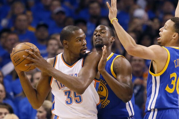 Oklahoma City Thunder forward Kevin Durant (35) is guarded by Golden State Warriors forward Harrison Barnes (40) and guard Stephen Curry (30) during the first quarter in Game 3 of the NBA basketball Western Conference finals  in Oklahoma City, Sunday, May 22, 2016. (AP Photo/Sue Ogrocki)