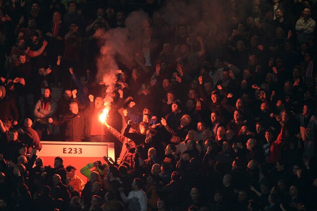 Flares are lit by the Liverpool supporters during the UEFA Europa League round of 16, second leg football match between Manchester United and Liverpool at Old Trafford in Manchester, north west England on March 17, 2016.
The game ended 1-1, Liverpool going through 3-1 on aggregate. / AFP / OLI SCARFF        (Photo credit should read OLI SCARFF/AFP/Getty Images)