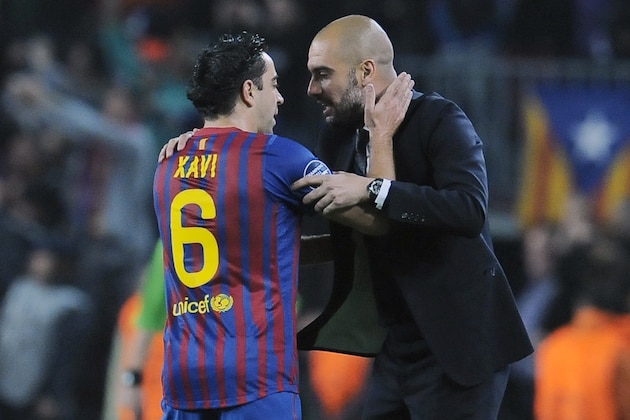FC Barcelona's coach Pep Guardiola, right, gives instructions to his fellow teammate Xavi Hernandez, during their Champions League second leg, quarterfinal soccer match, against AC Milan, at Camp Nou stadium in Barcelona, Spain Tuesday April 3, 2012. (AP Photo/Alvaro Barrientos)