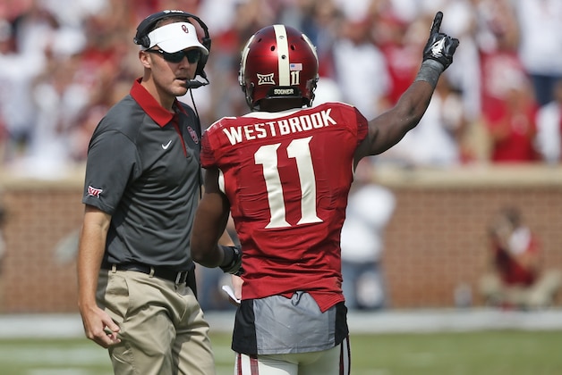 Lincoln Riley, Oklahoma offensive coordinator, left, talks with wide receiver Dede Westbrook (11) during an NCAA college football game against West Virginia in Norman, Okla., Saturday, Oct. 3, 2015. Oklahoma won 44-24. (AP Photo/Sue Ogrocki)