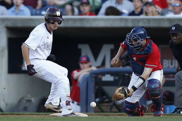 Mississippi State's Jake Mangum beats a throw back to first base after hitting a single and looking to stretch it into a double, as Mississippi catcher Henri Lartigue (22) covers the base in the Governor's Cup college baseball game at Trustmark Park in Pearl, Miss., Tuesday, April 26, 2016. (AP Photo/Rogelio V. Solis)