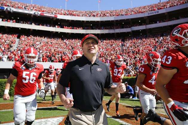 New Georgia head coach Kirby Smart runs into a packed Sanford Stadium with his players for the their spring  intrasquad NCAA college football game Saturday, April 16, 2016, in Athens, Ga.  (AP Photo/John Bazemore)