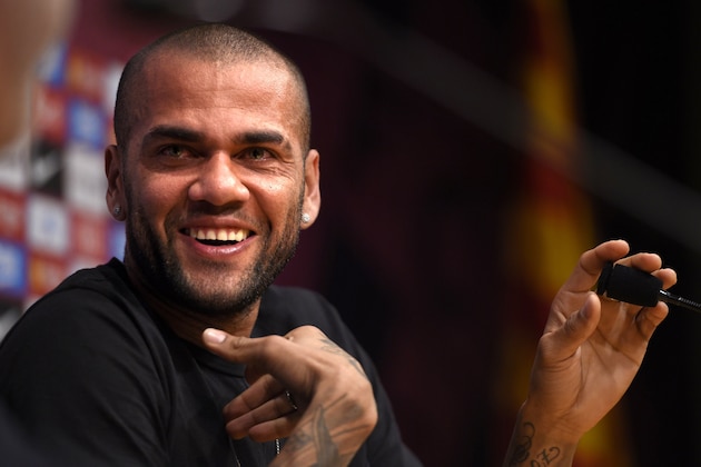 Barcelona's Brazilian defender Dani Alves smiles during a press conference at Camp Nou stadium in Barcelona on June 10, 2015. Dani Alves put an end to speculation about his future when he signed a two-year extension to his deal with recently-crowned European champions Barcelona on June 9, 2015.  AFP PHOTO / LLUIS GENE        (Photo credit should read LLUIS GENE/AFP/Getty Images)