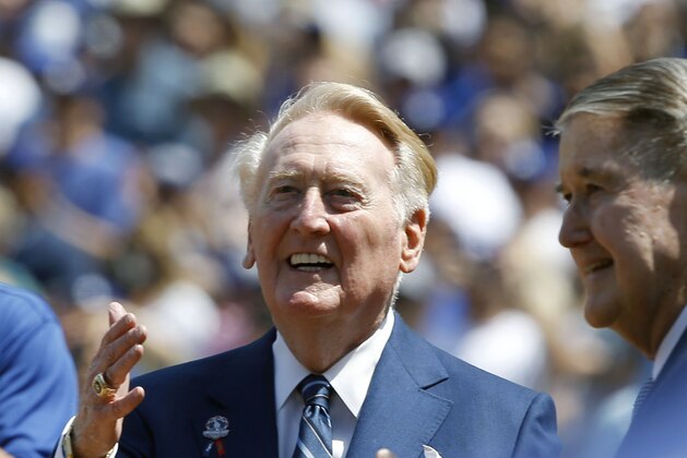 Los Angeles Dodgers broadcaster Vin Scully, left, looks up in the stands with former owner Peter O'Malley as Scully is honored before the start of an opening day baseball game against the Arizona Diamondbacks in Los Angeles, Tuesday, April 12, 2016. (AP Photo/Alex Gallardo)