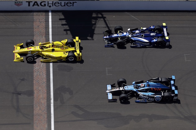 Helio Castroneves, of Brazil, leads Carlos Munoz, of Colombia, (26) and Josef Newgarden across the start/finish line on the main straightway during a practice session for the Indianapolis 500 auto race at Indianapolis Motor Speedway in Indianapolis, Monday, May 23, 2016. (AP Photo/Michael Conroy)