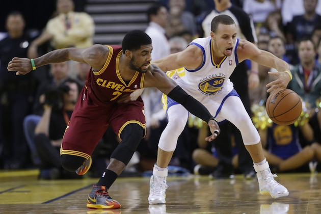 Cleveland Cavaliers guard Kyrie Irving, left, battles for a loose ball against Golden State Warriors guard Stephen Curry during the first half of an NBA basketball game on Friday, March 14, 2014, in Oakland, Calif. (AP Photo/Marcio Jose Sanchez)