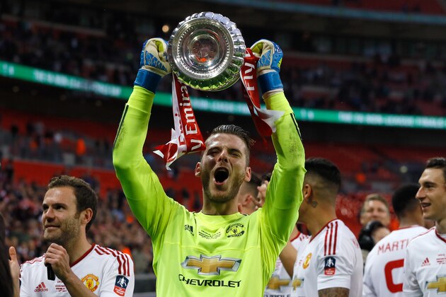 United’s goalkeeper David de Gea holds the trophy after they won the English FA Cup final soccer match between Manchester United and Crystal Palace at Wembley stadium in London, Saturday, May 21, 2016. United won 2-1. (AP Photo/Kirsty Wigglesworth)