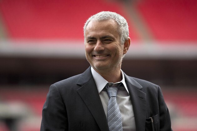 FILE- In this Monday, Feb. 1, 2016 file photo, former Chelsea manager Jose Mourinho smiles as he attends a group photo session pitchside as a guest of FIFA Presidential Candidate Gianni Infantino at Wembley Stadium in London. Manchester United has announced Friday, May 27, 2016, they have hired Jose Mourinho as its new manager, entrusting one of soccer’s most successful coaches to restore the fortunes of England’s most prestigious club,  (AP Photo/Matt Dunham, File)