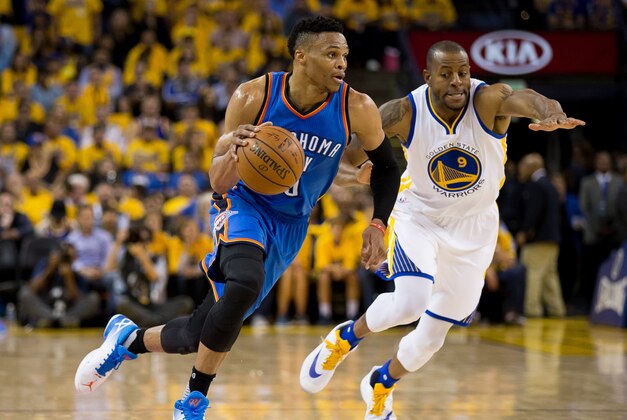 May 26, 2016; Oakland, CA, USA; Oklahoma City Thunder guard Russell Westbrook (0) dribbles the ball around Golden State Warriors forward Andre Iguodala (9) during the third quarter in game five of the Western conference finals of the NBA Playoffs at Oracle Arena. Mandatory Credit: Kelley L Cox-USA TODAY Sports
