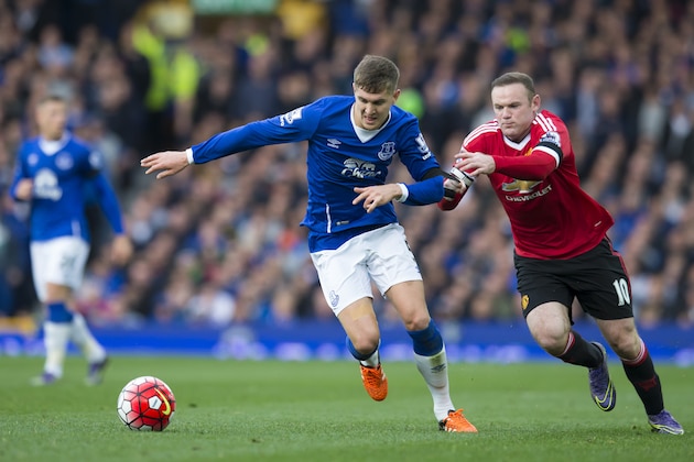 Manchester United's Wayne Rooney, right, grabs a hold of Everton's John Stones during the English Premier League soccer match between Everton and Manchester United at Goodison Park Stadium, Liverpool, England, Saturday Oct. 17, 2015. (AP Photo/Jon Super)