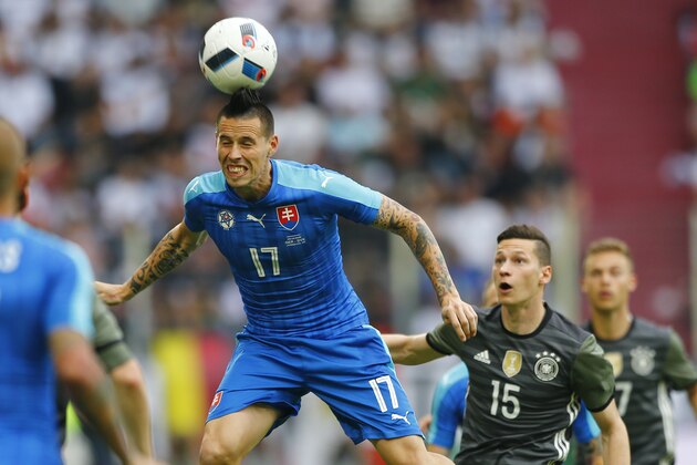 Slovakia’s Marek Hamsik, left, and Germany’s Julian Draxler challenge for the ball during a friendly soccer match between Germany and Slovakia in Augsburg, Germany,  Sunday, May 29, 2016. (AP Photo/Matthias Schrader)